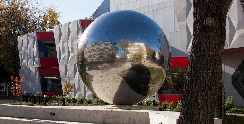 A photo showing a large reflective ball in the grounds of a university